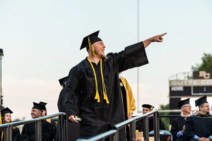 Butte College Student points to crowd at commencement ceremony