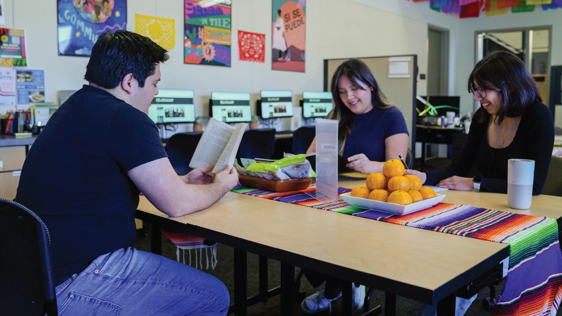 Three Butte College CASA students sit at a table in the casa lounge