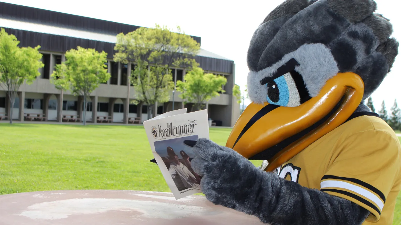 Dash Mascot reading roadrunner paper