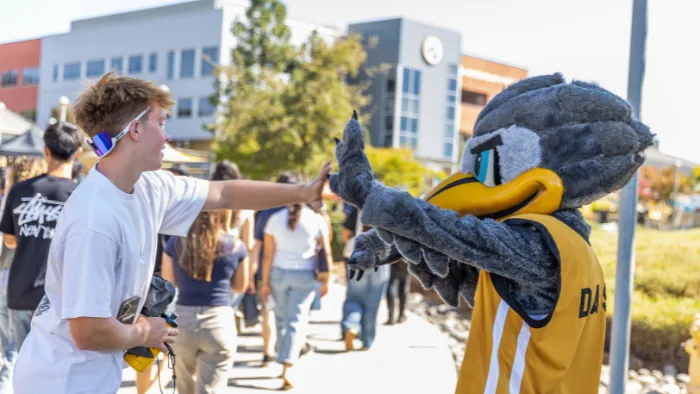 Butte College Roadrunner rush a student gives dash a high five
