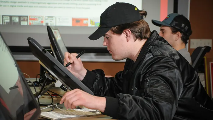 Butte College graphic design student drawing on computer