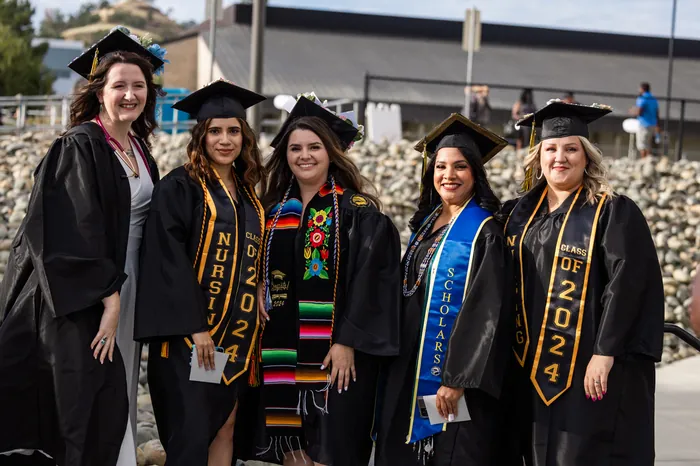 Five Butte College graduates pose together in their caps and gowns. 