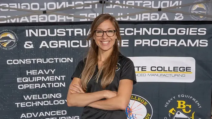 Butte College industrial tech professor poses in front of banner