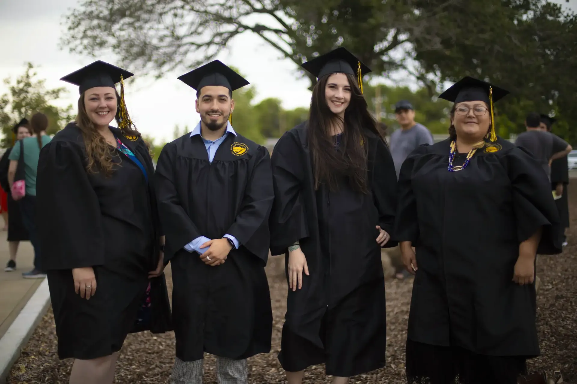 Four Butte College Graduates pose for photo at commencement ceremony