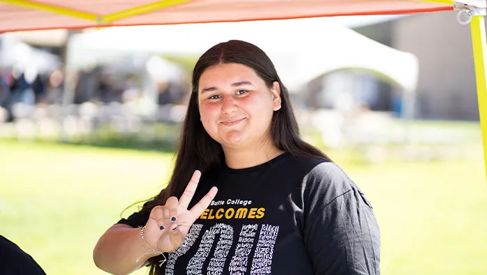 Butte College Student flashes peace sign and a smile on campus