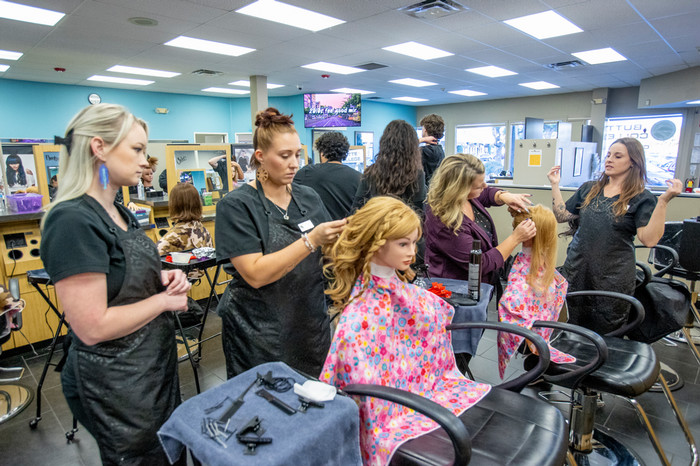 students styling hair of models