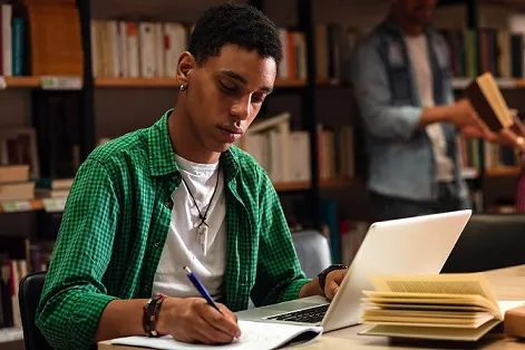 Student works on laptop in library