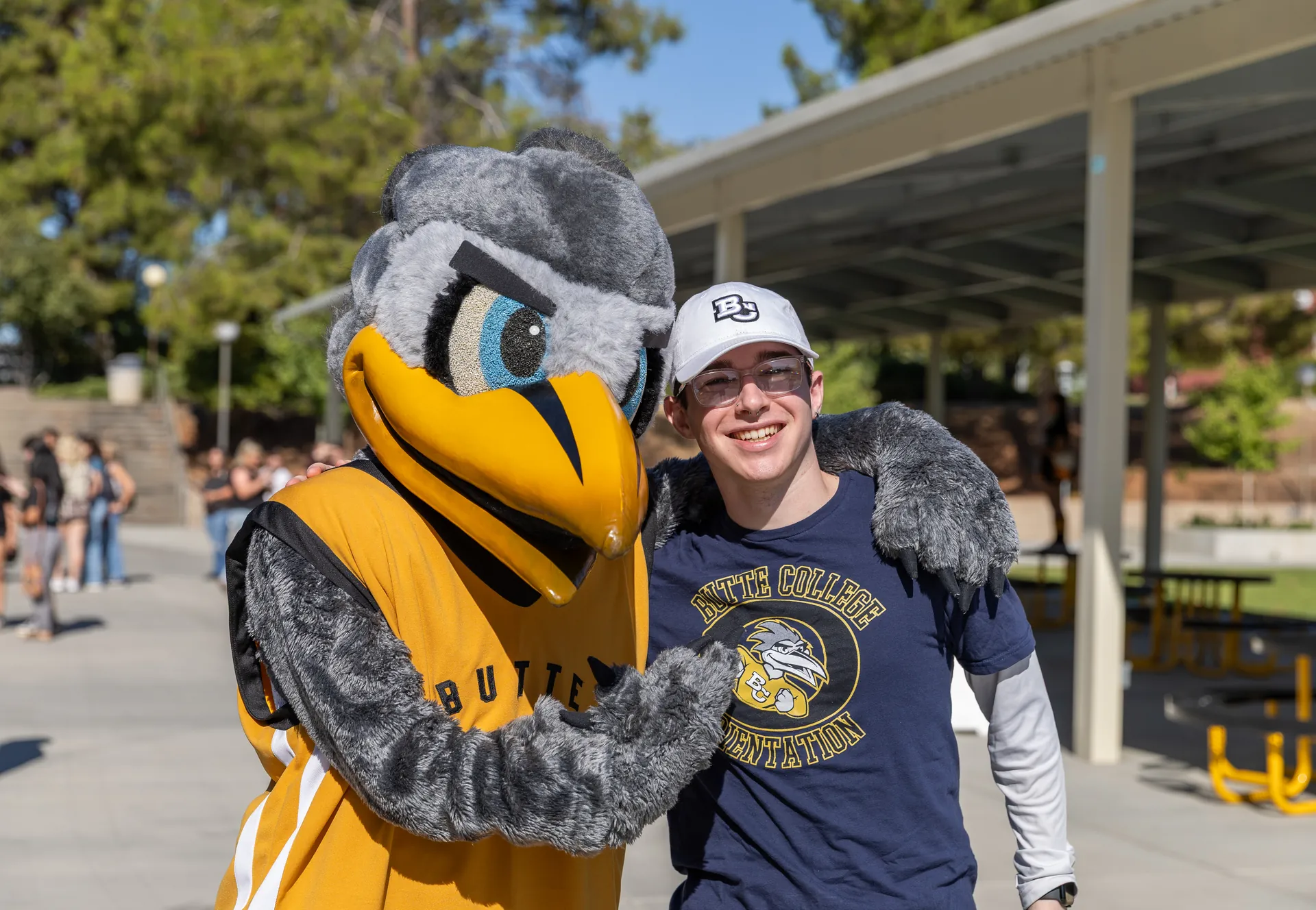 Butte College Student poses with Dash Mascot on campus