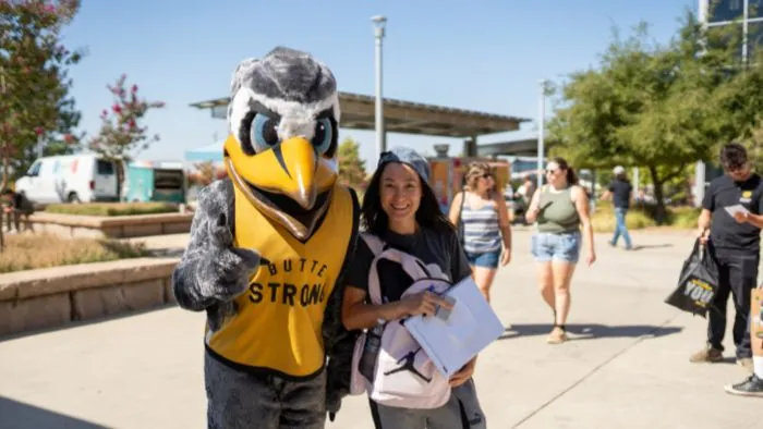 Butte College Student poses with Dash Mascot on campus