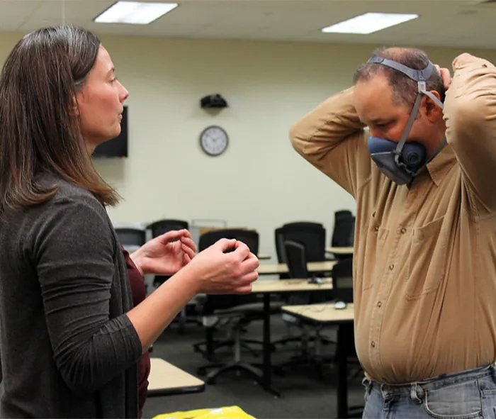 Instructor demonstrates proper respirator mask usage at the Training Place