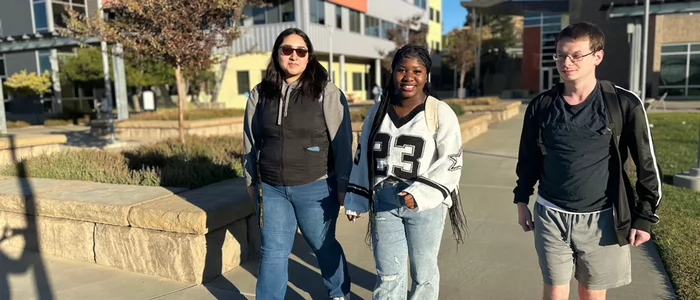 three-students-walking-on-campus