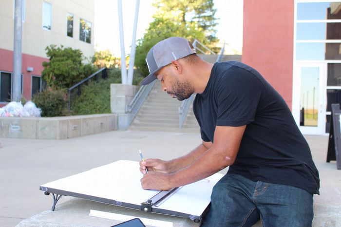 drafing-student-works-on-project-outside
