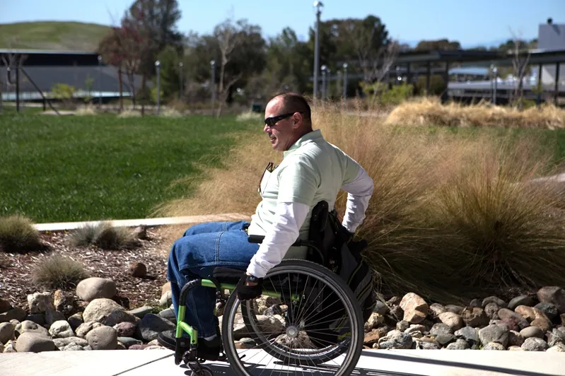 Butte College DSPS Support Program participant operates wheelchair across campus